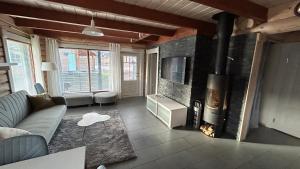 a living room with a couch and a fireplace at Villa Laakson Helmi 1 с камином, сауной, SPA, на берегу озера in Himos