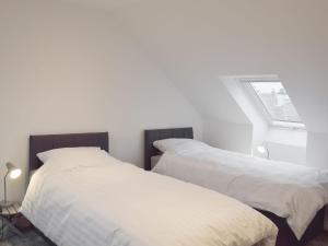 two beds sitting next to each other in a bedroom at Hunter Links Cottage in Prestwick