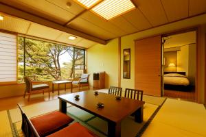 Jodogahama Park Hotel في مياكو: غرفة معيشة مع طاولة وغرفة نوم