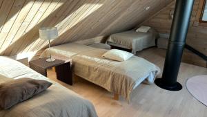 a attic room with two beds and a lamp at Villa Laakson Helmi 1 с камином, сауной, SPA, на берегу озера in Himos