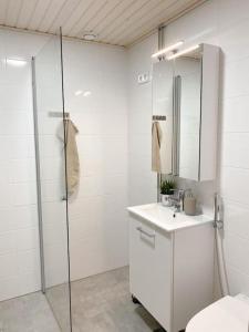 La salle de bains est pourvue d'une douche, d'un lavabo et de toilettes. dans l'établissement Modern and cozy apartment with Sauna, à Espoo