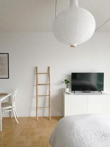 a bedroom with a bed and a tv and a chair at Modern and cozy apartment with Sauna in Espoo