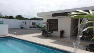 une villa avec une piscine et une maison dans l'établissement LA ESCONDIDA, à Tonsupa