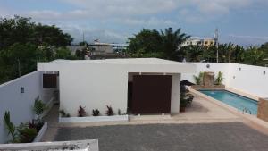 - un bâtiment blanc avec une porte et une piscine dans l'établissement LA ESCONDIDA, à Tonsupa