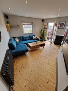 a living room with a blue couch and a table at Beach front apartment in Edinburgh