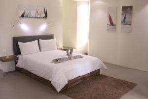 un dormitorio con una cama con un pájaro sentado en ella en Valmarin Seafront Apartments, en Trou d'Eau Douce