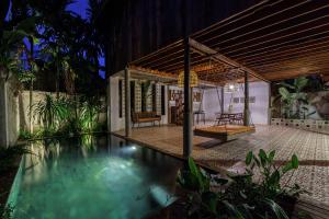 a villa with a swimming pool at night at Dontrei Villa Angkor in Siem Reap