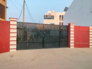 a black metal gate with a red fence at Hotel Dev Inn Ayodhya in Ayodhya