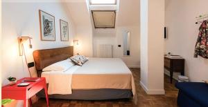 ein kleines Schlafzimmer mit einem Bett und einem roten Tisch in der Unterkunft Mansarda Bellini 84 in Neapel