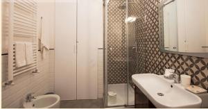 ein weißes Bad mit einem Waschbecken und einer Dusche in der Unterkunft Mansarda Bellini 84 in Neapel