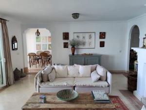 een woonkamer met een witte bank en een tafel bij Frontline Beach Apartment, La Perla de la Bahia, Bahia de Casares - Estepona in Casares
