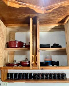 a wooden cabinet filled with pots and pans at K&GTransient House in Baguio