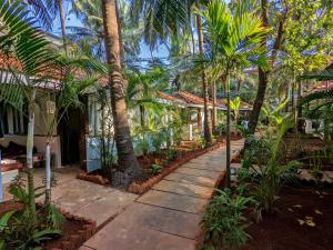 un passaggio pedonale di fronte a una casa con palme di De Soul Sante Beach Resort Morjim Goa a Morjim