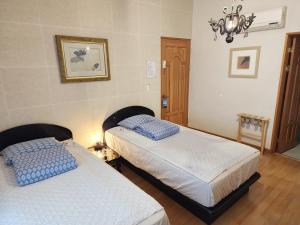 a bedroom with two beds and a chandelier at Tong Stay in Tongyeong