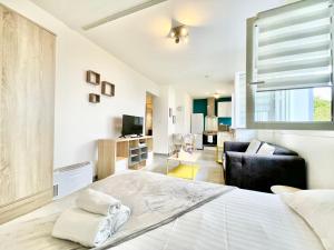 a bedroom with a large bed and a living room at Saint Nazaire - Le Sembat - Proche mer - Wifi fibre in Saint-Nazaire