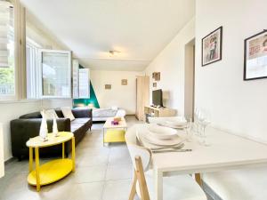 a living room with a couch and a table and chairs at Saint Nazaire - Le Sembat - Proche mer - Wifi fibre in Saint-Nazaire