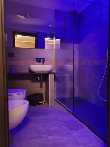 a purple bathroom with a sink and a toilet at Room4You in Oulx