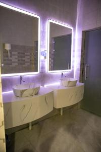 a bathroom with two sinks and two mirrors at فندق روش بلس in Hafr Al Baten