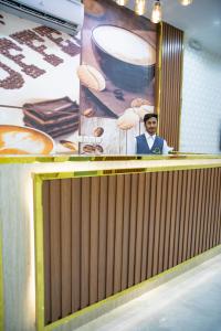 a man is standing behind a podium in a room at فندق روش بلس in Hafr Al Baten