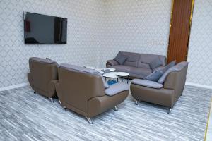 a waiting room with two couches and a tv at فندق روش بلس in Hafr Al Baten