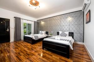 a bedroom with two beds and a large wall at The Sanctuary Residence in Siem Reap