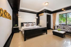 um quarto com uma cama e um sofá em The Sanctuary Residence em Siem Reap