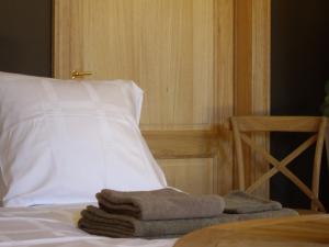 une pile de serviettes assises au-dessus d'un lit dans l'établissement B&B Schoon Goed, à Gingelom