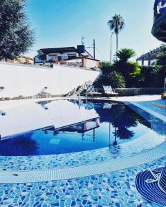 a swimming pool with chairs and a reflection in the water at Villa Elisabetta in Pompei