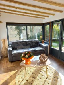 uma sala de estar com um sofá e uma mesa em Villa Cosy Pierrefonds em Pierrefonds