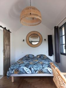 - une chambre avec un lit et une lampe pendant dans l'établissement Villa Cosy Pierrefonds, à Pierrefonds