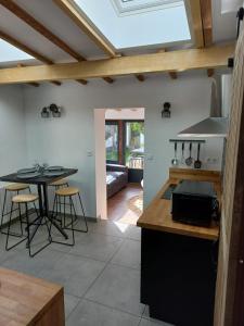 eine Küche mit einem Tisch und einem Herd Top-Backofen in der Unterkunft Villa Cosy Pierrefonds in Pierrefonds