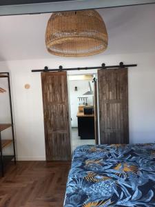- une chambre avec un lit et 2 portes en bois dans l'établissement Villa Cosy Pierrefonds, à Pierrefonds