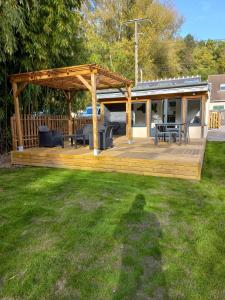 eine Holzterrasse mit einem Pavillon im Hof in der Unterkunft Villa Cosy Pierrefonds in Pierrefonds