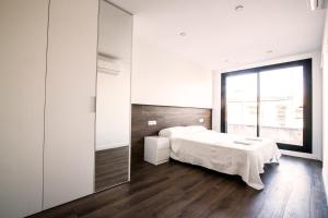 1 dormitorio con cama y ventana grande en 3-1 Apartamento de diseño en el centro de Reus, en Reus