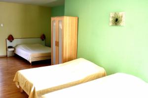 two beds in a room with green walls at In Jungle Hôtel in Chassagny