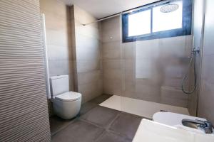 baño con aseo y lavabo y ventana en Atico con terraza en el centro de Reus, en Reus