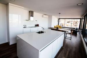 a kitchen with white cabinets and a white counter top at Atico con terraza en el centro de Reus in Reus