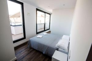 sypialnia z łóżkiem i 2 oknami w obiekcie Atico con terraza en el centro de Reus w mieście Reus