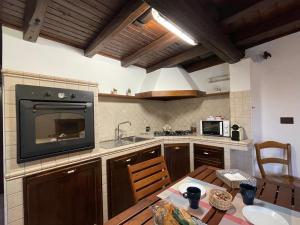 a kitchen with a table and a tv on the wall at La CASETTA di Antonietta in Fiumicino