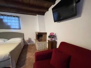 a bedroom with a bed and a tv and a couch at La CASETTA di Antonietta in Fiumicino