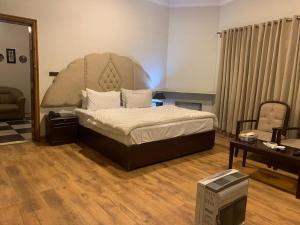 1 dormitorio con 1 cama con cabecero grande en The Exclusive House, en Peshawar