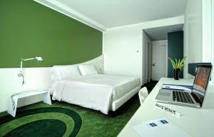 a hotel room with a bed and a desk with a laptop at Idea Hotel Milano Malpensa Airport in Case Nuove