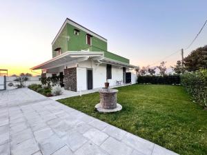 uma casa verde e branca com um jardim de relva em IL CASALE POMPEIANO em Pompeia