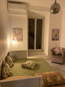 1 dormitorio con cama con almohadas y sofá en Flowers in Rome en Roma