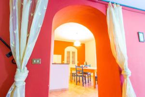 an archway into a dining room with an orange wall at Albergo diffuso "Centoborghi" in Fivizzano