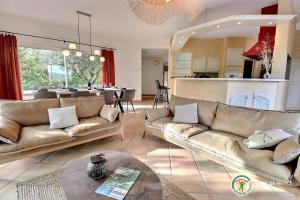 ein Wohnzimmer mit 2 Sofas und einer Küche in der Unterkunft Les Terrasses de Saint-Alban in Saint Alban Auriolles