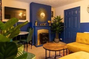 un soggiorno con pareti blu e camino di Stay in the heart of Isle of Wight in 2BDR apt a Newport
