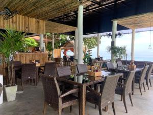 a restaurant with tables and chairs and the ocean at 4U Resort Samui in Lamai