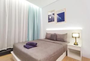 a bedroom with a bed with purple pillows on it at The Blueprint @ Bangsar South Mid Valley in Kuala Lumpur