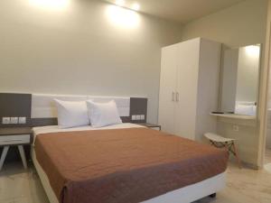 a bedroom with a bed with a desk and a cabinet at AKTES PIERIAS (GARDEN ROOMS) in Paralia Katerinis